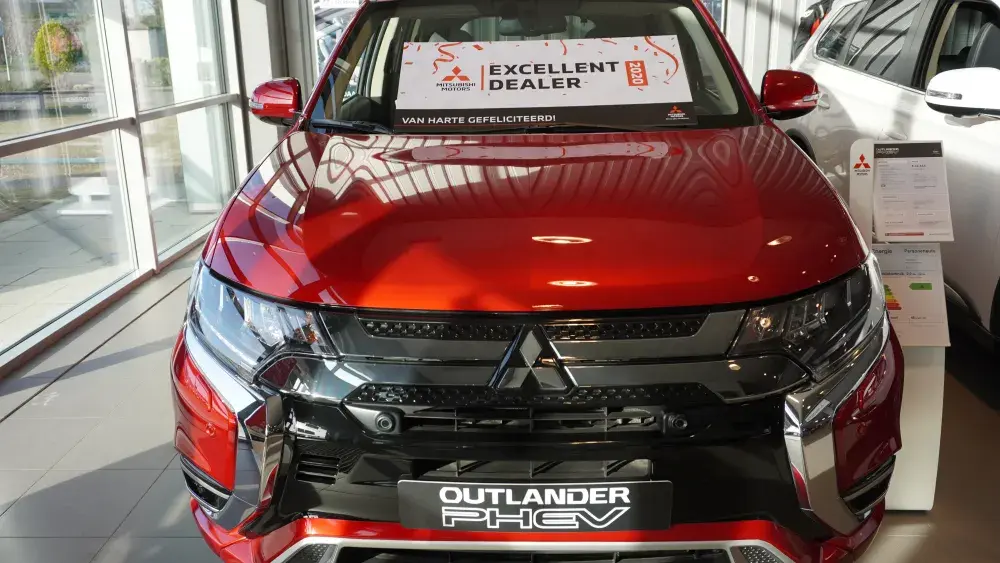 Bord Mitsubishi Outlander PHEV met bord Excellent Dealer 2020 in showroom
