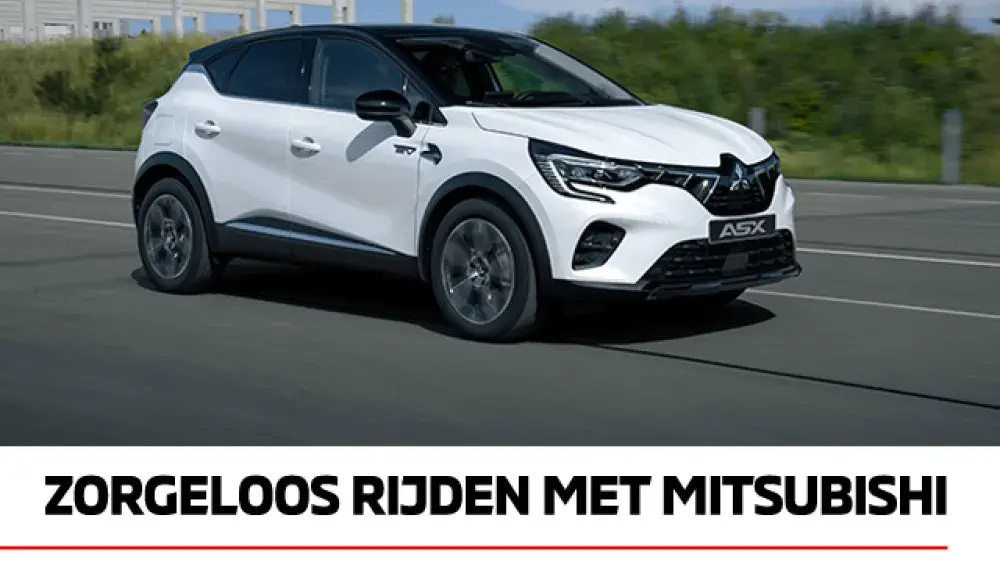 Witte Mitsubishi ASX MY2023 op snelweg met op de achtergrond een gebouw in aanbouw