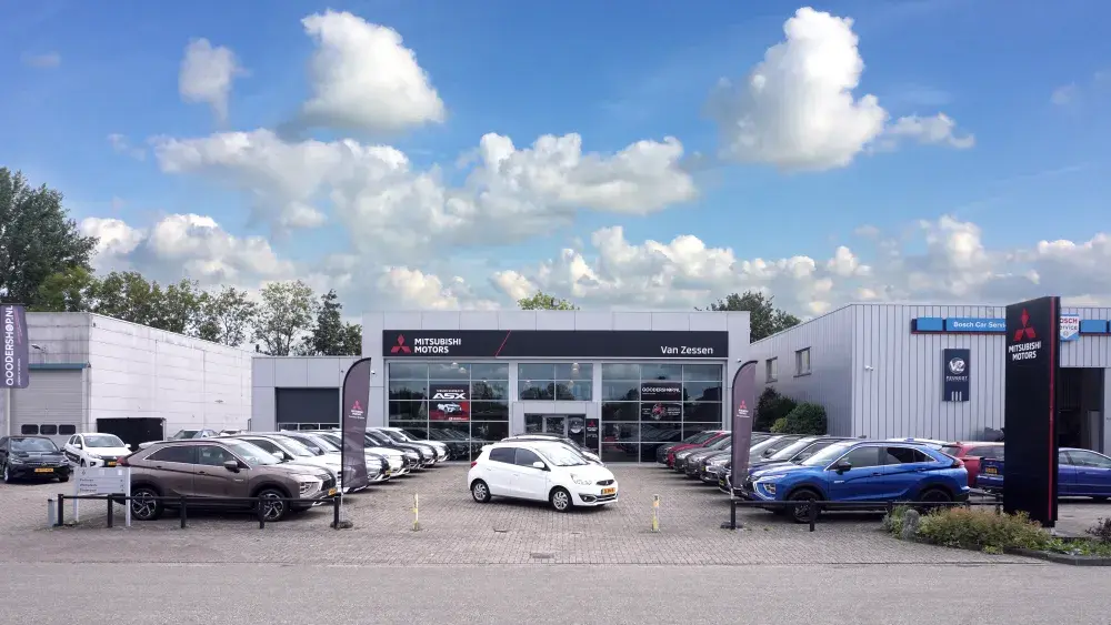 Aanzicht showroom Autobedrijf Van Zessen Lexmond met mooie wolken lucht